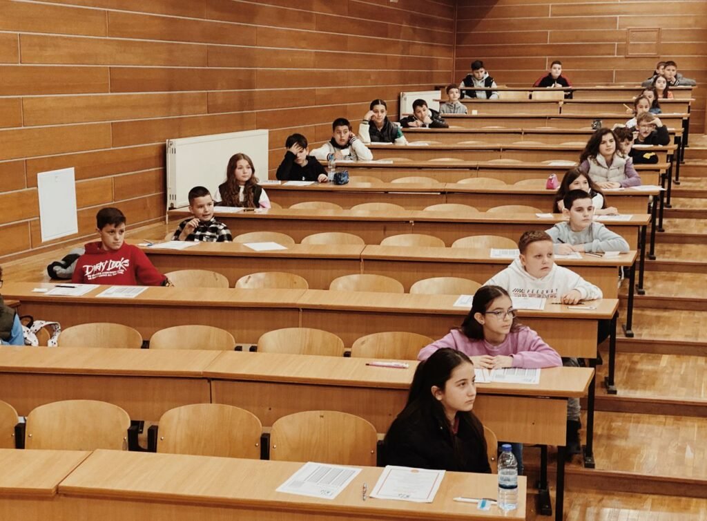 Students seated in rows in a lecture hall, focused on their exams.